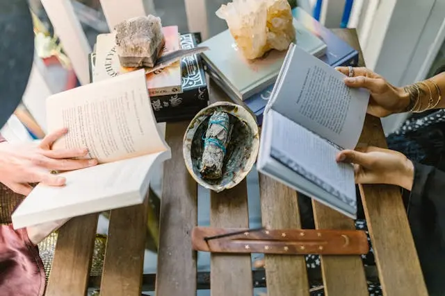 dos personas en una mesa leyendo un libro