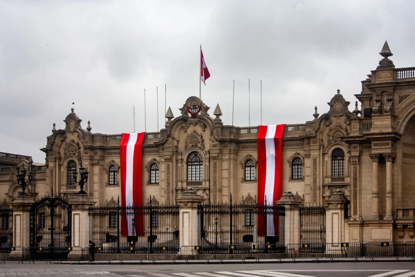 Bandera colocada en una fachada, balcón o espacio público. Debe verse claramente que corresponde a Perú